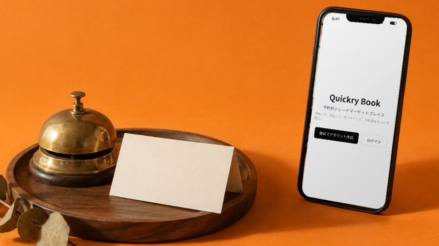 Quickry Book の画面を表示したスマートフォンと受付の呼び鈴